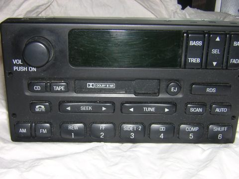 1998 Ford Crown Victoria - A car stereo unit is shown, a digital display and a variety of control buttons for audio functions.