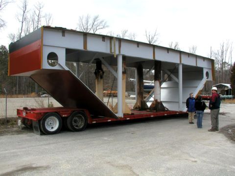 1988 Ford Bronco - A trailer transports a large, unfinished industrial component outdoors.