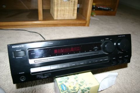 2003 Jeep TJ - A black Kenwood audio receiver is shown from the front, resting on a carpeted floor.