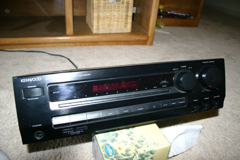 Black Kenwood audio receiver with red display and knobs