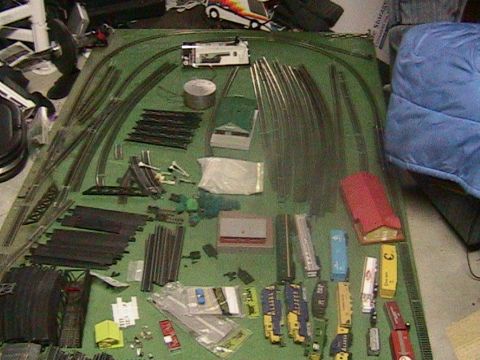 1981 Chevrolet C/K Pickup - A collection of model train tracks and cars are laid out on a green surface, suggesting a hobbyist's setup.