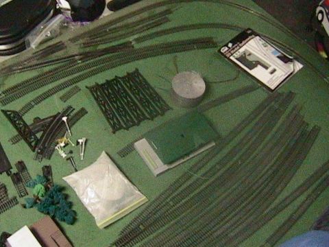 1981 Chevrolet C/K Pickup - Various model train tracks and accessories are laid out on a green surface.