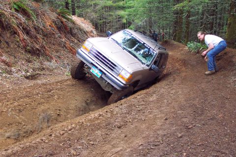 1994 Ford Explorer - Ford Explorer navigating a challenging off-road obstacle on a dirt trail.