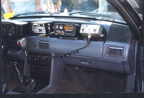1991 Ford Mustang - The dashboard of a car is equipped with several radio communication devices and a microphone.