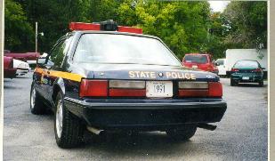 1991 Ford Mustang - This 1991 Ford Mustang SSP police car is seen from the rear, displaying 'STATE POLICE' on its trunk and a 1991 license plate.