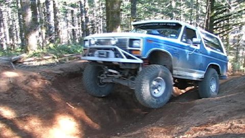 1996 Ford Bronco - This modified SUV navigates a challenging off-road course in a wooded area.
