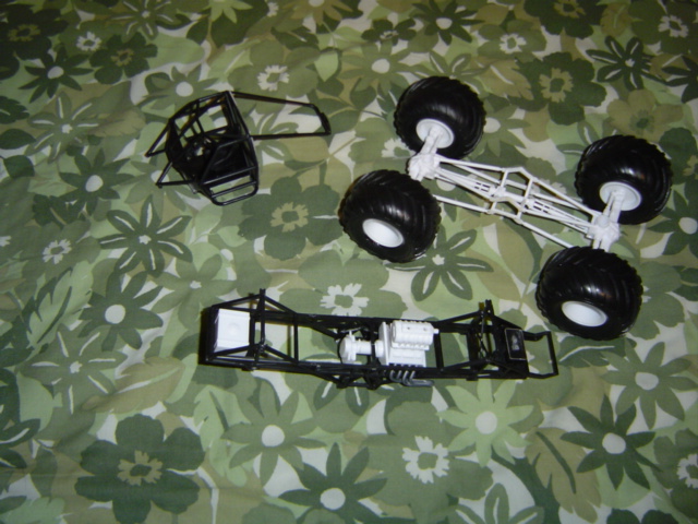 model kit chassis, engine, cab, and wheels laid out on a floral sheet