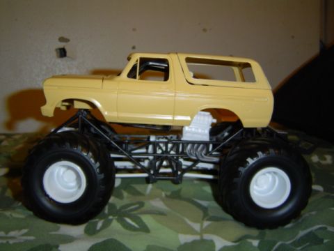 1979 Ford Bronco - A model of a 1979 Ford Bronco modified into a monster truck sits on a patterned surface.