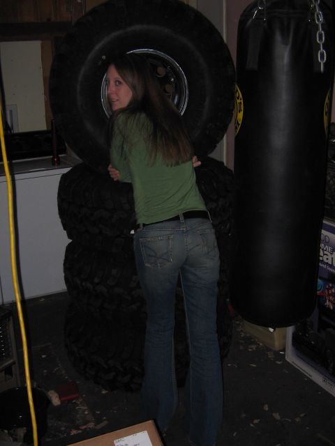 1978 Ford Bronco - A woman poses with oversized tires in what appears to be a garage or workshop.