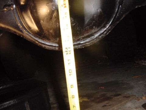 1971 Ford Bronco - A yellow measuring tape is shown against a dark, metallic component, likely part of a vehicle's drivetrain.