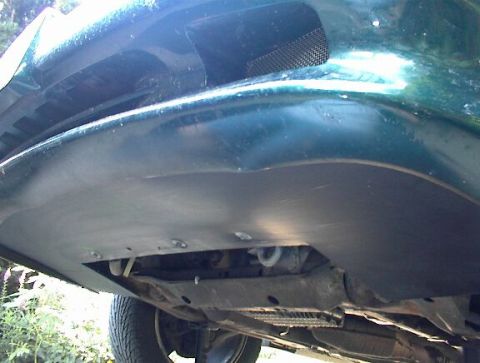 1993 Ford Taurus - Close-up of the underside of a car's front bumper and splash shield, showing mechanical components.