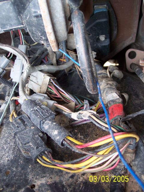 1987 Ford Bronco - Close-up view of a complex engine compartment wiring harness, showing various connectors and multicolored wires.