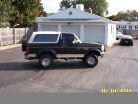 1992 Ford Bronco - Side view of a 1992 Ford Bronco with a white removable top.