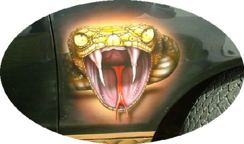 1978 Ford Mustang II - A striking airbrushed cobra design adorns the side panel of a vehicle, complete with visible tire tread.