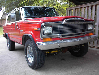 1993 Ford Bronco - A red 1984 Jeep Grand Wagoneer is shown from a three-quarter front angle.