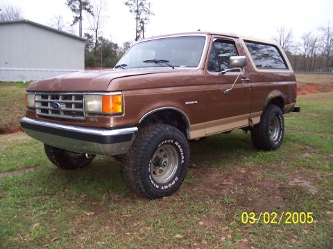 1987 Ford Bronco - This 1987 Ford Bronco features a two-tone brown and tan paint scheme and appears to have a lifted suspension.