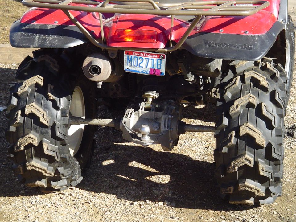 Red ATV rear view with knobby tires and South Dakota license plate M02718