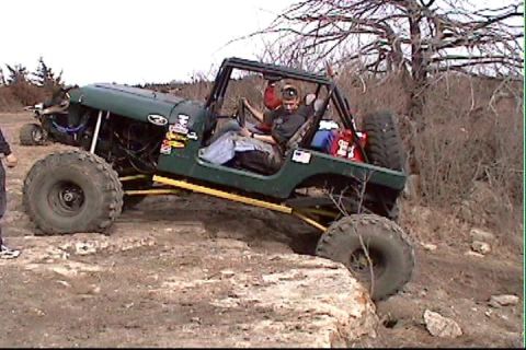 1983 Ford Bronco - This modified Jeep is navigating a rocky obstacle course with a second vehicle in the background.