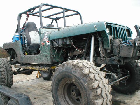 1983 Ford Bronco - This heavily modified Jeep Wrangler features oversized tires, a custom roll cage, and exposed engine components, suggesting it's built for…