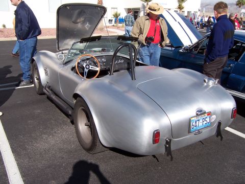 1971 Ford Mustang - A silver Shelby Cobra replica is parked with its hood open, alongside another vehicle.