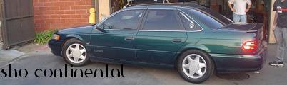 1993 Ford Taurus - This 1993 Ford Taurus sedan is shown from the side, with text on the door reading 'sho continental'.