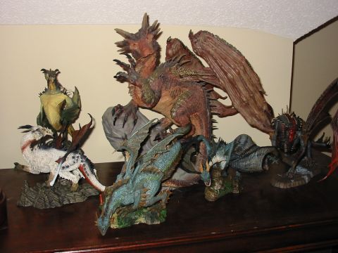 1991 Ford Bronco - Several detailed dragon figurines are displayed on a wooden shelf against a light-colored wall.