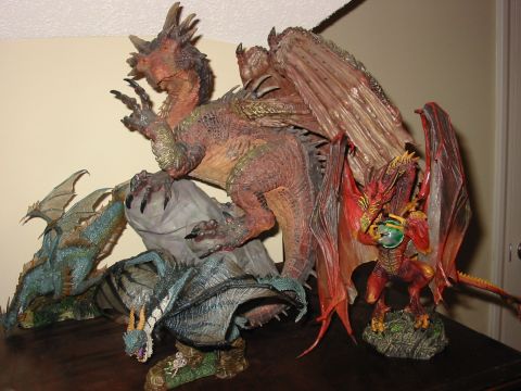 1991 Ford Bronco - A collection of detailed dragon figurines are displayed together, with a prominent red dragon figure in the foreground.