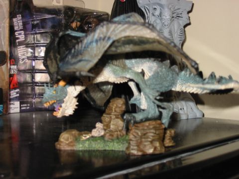 1991 Ford Bronco - A detailed dragon figurine is displayed on a shelf, with packaging for a 'Colonial Marine Cpl. Hicks' action figure visible behind it.