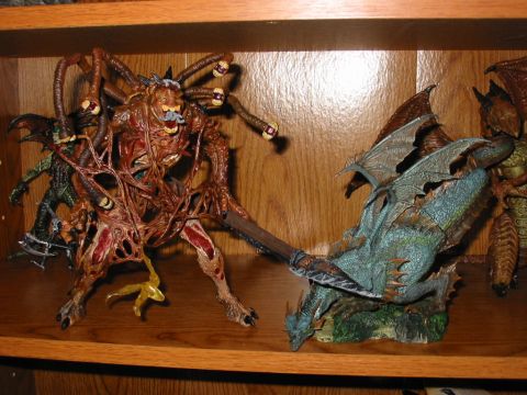 1991 Ford Bronco - Two fantasy figures, a grotesque monster and a dragon, are displayed on a wooden shelf.