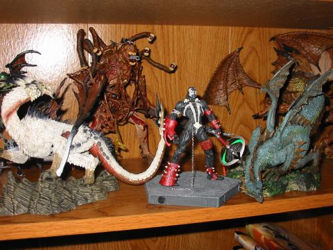 1991 Ford Bronco - A collection of fantasy action figures, including Spawn and various dragons, are displayed on a wooden shelf.