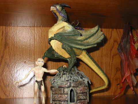 1991 Ford Bronco - A fantasy figurine depicting a dragon and a small humanoid figure is displayed on a shelf.