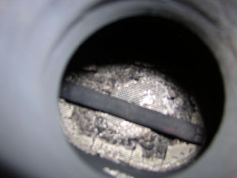 1995 Ford Bronco - Close-up view inside an exhaust pipe, showing a clogged catalytic converter grid.