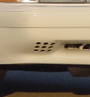 1993 Ford Mustang - Close-up of a white vehicle's front bumper, revealing distinctive grille patterns.
