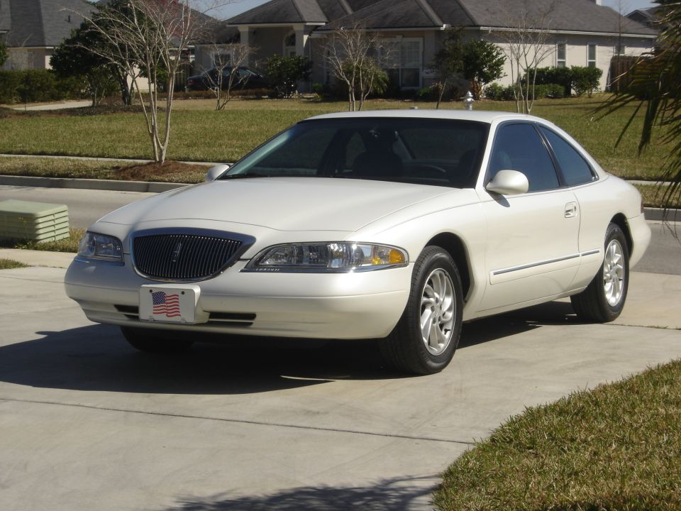 White 1997 Lincoln Mark VIII parked on a driveway in front of a house