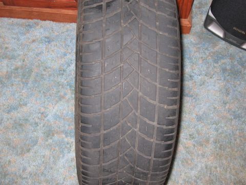 1994 Ford Probe - A single tire is shown in detail, with its tread pattern clearly visible against a carpeted background.