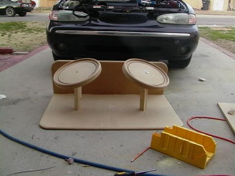 1999 Ford Taurus - A 1999 Ford Taurus is parked with its hood open, positioned behind two wooden speaker mounts on a concrete driveway.
