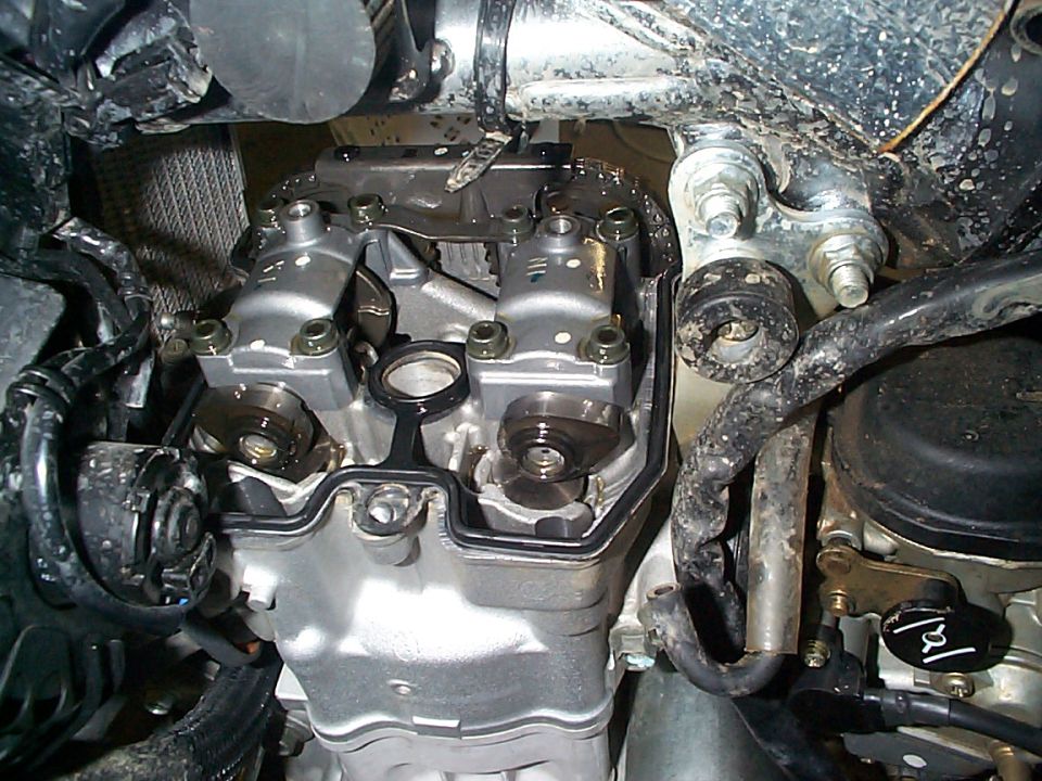 Underside view of a twin-cam engine and timing chain cover with road grime