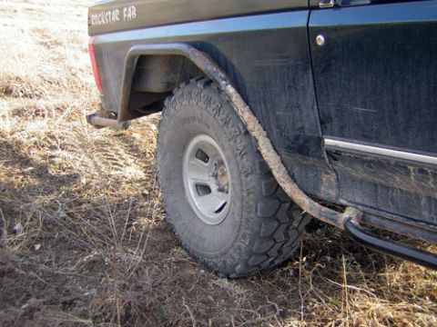 1995 Ford Bronco - Close-up of a 1995 Ford Bronco's rear tire and side panel with custom fabrication visible.