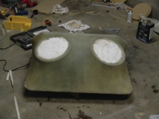 Unfinished fiberglass panel with two oval cutouts on a garage floor