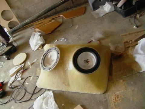 1999 Ford Taurus - Custom speaker enclosure with two subwoofers, likely for a car interior, sits on a workshop floor.