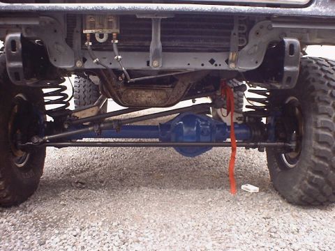 1988 Ford Bronco - Close-up view of the front axle and suspension system of an off-road vehicle.