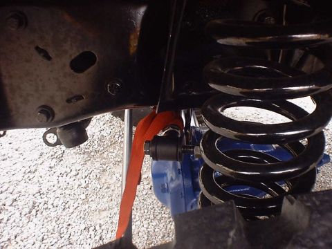 1988 Ford Bronco - Suspension part with an orange strap attached to a rod, with a blue component visible.