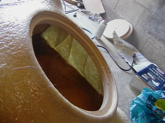 Fiberglass custom speaker enclosure panel with oval opening on garage floor