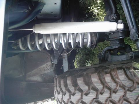 1978 Ford Bronco - Close-up of the front suspension system of a 1978 Ford Bronco, showing the shock absorber and coil spring.