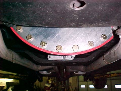 1967 Ford Galaxie - Close-up of an aftermarket part installed on a vehicle's undercarriage, showing bolted connections and exhaust system.