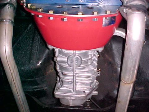 1967 Ford Galaxie - Underside view of a vehicle's transmission and exhaust system, with a red transmission cover.