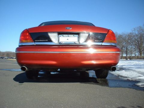 1999 Ford Crown Victoria - Rear view of a red Ford Crown Victoria with a black accent panel and chrome trim.