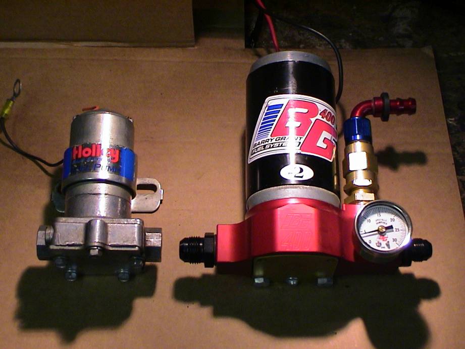 Holley and Barry Grant fuel pumps side-by-side, one with a pressure gauge