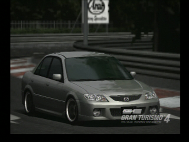 Silver sedan on a race track, likely from a video game