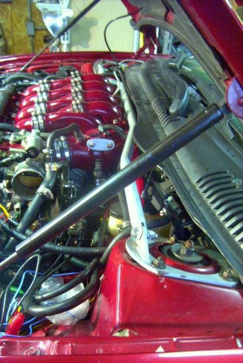 1997 Ford Taurus - The engine bay of a red vehicle, showing the intake manifold and associated components.